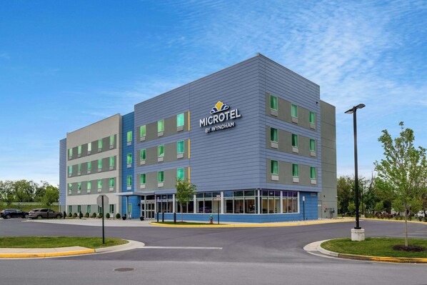 A modern Microtel hotel by Wyndham with a blue and gray exterior, multiple windows, and a parking lot. - Microtel Inn & Suites by Wyndham Winchester (Winchester)