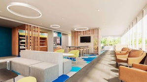 A modern lounge area with seating, a TV, and a children's play area. - Microtel Inn & Suites by Wyndham Winchester (Winchester)