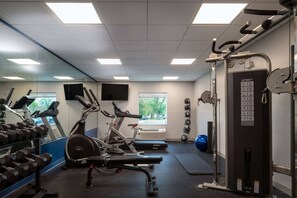 A gym with exercise equipment, a mirror, and a window. - Microtel Inn & Suites by Wyndham Winchester (Winchester)