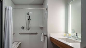 A modern bathroom with a glass-enclosed shower, a white sink, and a mirror.