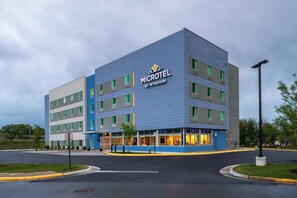 A modern Microtel hotel with a blue and grey facade, multiple floors, and a well-lit entrance. - Microtel Inn & Suites by Wyndham Winchester (Winchester)