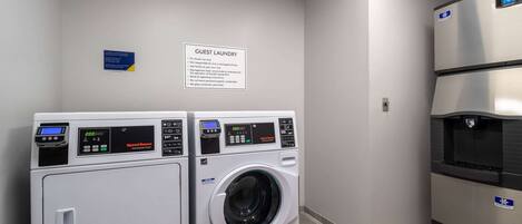 A guest laundry area with two washing machines and a refrigerator.