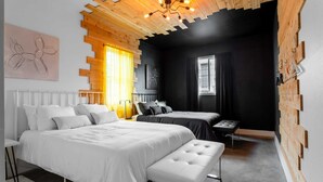 Una camera da letto moderna con soffitto in legno, due letti, una panca e un termosifone.