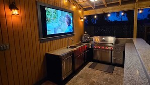 A kitchen with a TV, stainless steel appliances, and a stone floor. - 3 bedroom private vacation home in merritt island (Merritt Island)