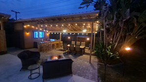 An outdoor patio area with a bar, seating, and a fire pit. - 3 bedroom private vacation home in merritt island (Merritt Island)