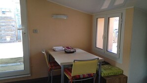A room with a table, chairs, a window, and a door. - Charming duplex, 25m2 roof terrace in the center of the old village, wifi (Collioure)