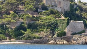 Un castillo histórico en una colina con vistas a un cuerpo de agua.