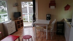 Una cocina compacta con comedor, televisor y cafetera.