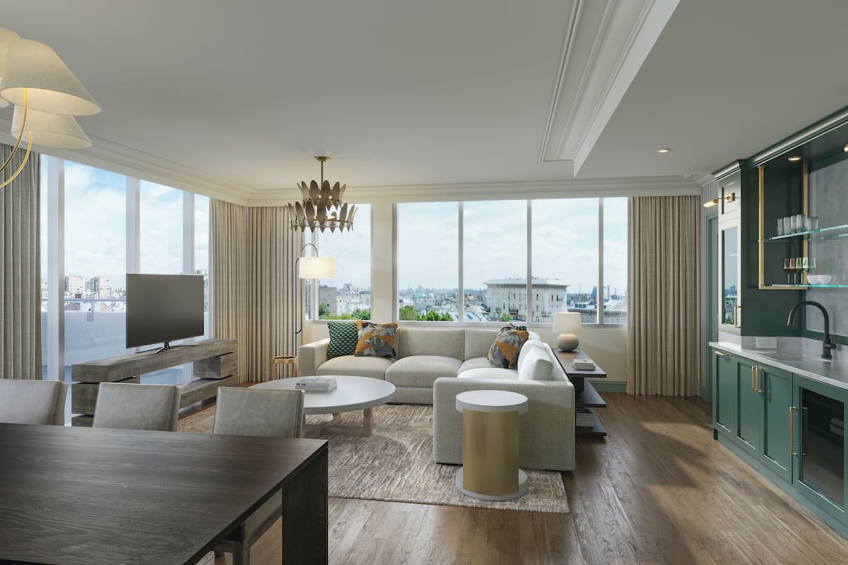 Una sala de estar moderna con un sofá, una mesa de centro, un televisor y vistas a la ciudad.