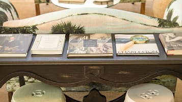 A cozy reading area with a sofa, a table with books, and decorative vases.