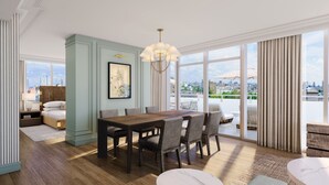 A dining area with a wooden table and chairs, a chandelier, and a city view through large windows. - The Palmetto Hotel (Charleston)