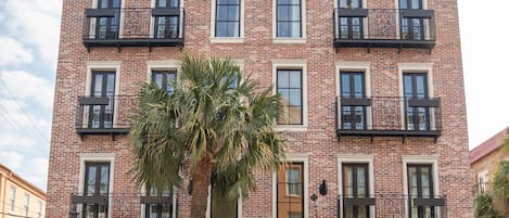 Un edificio de ladrillo con un letrero que dice "Palmetto Hotel" y una palmera en primer plano.
