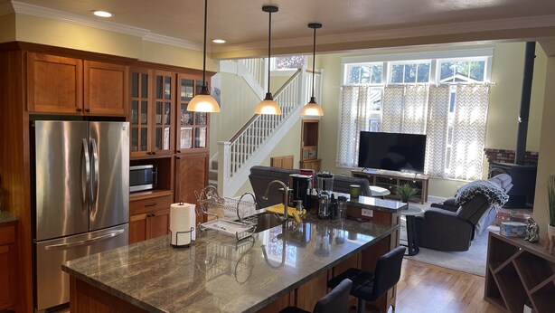 A modern kitchen with stainless steel appliances, wooden cabinets, and a central island.