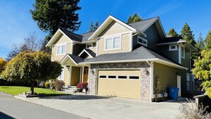 A two-story house with a stone facade, a garage, and a driveway.