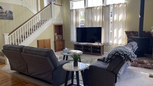 A living room with a sofa, a coffee table, a TV, and a fireplace.