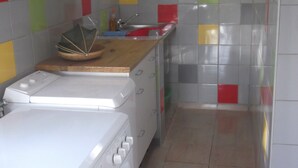 A compact kitchen with white appliances, a microwave, and a coffee maker.