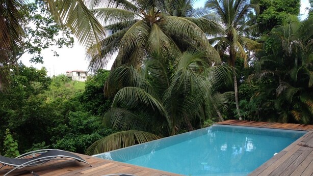 A pool area with wooden deck and lounge chairs.