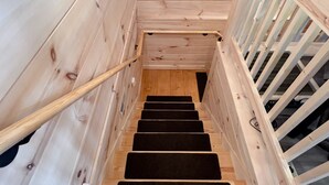A wooden staircase with a handrail and black carpeted steps leading to a landing. - Incredible Views, Hot Tub, Pool Table, Waterfalls, Hiking (Bryson City)