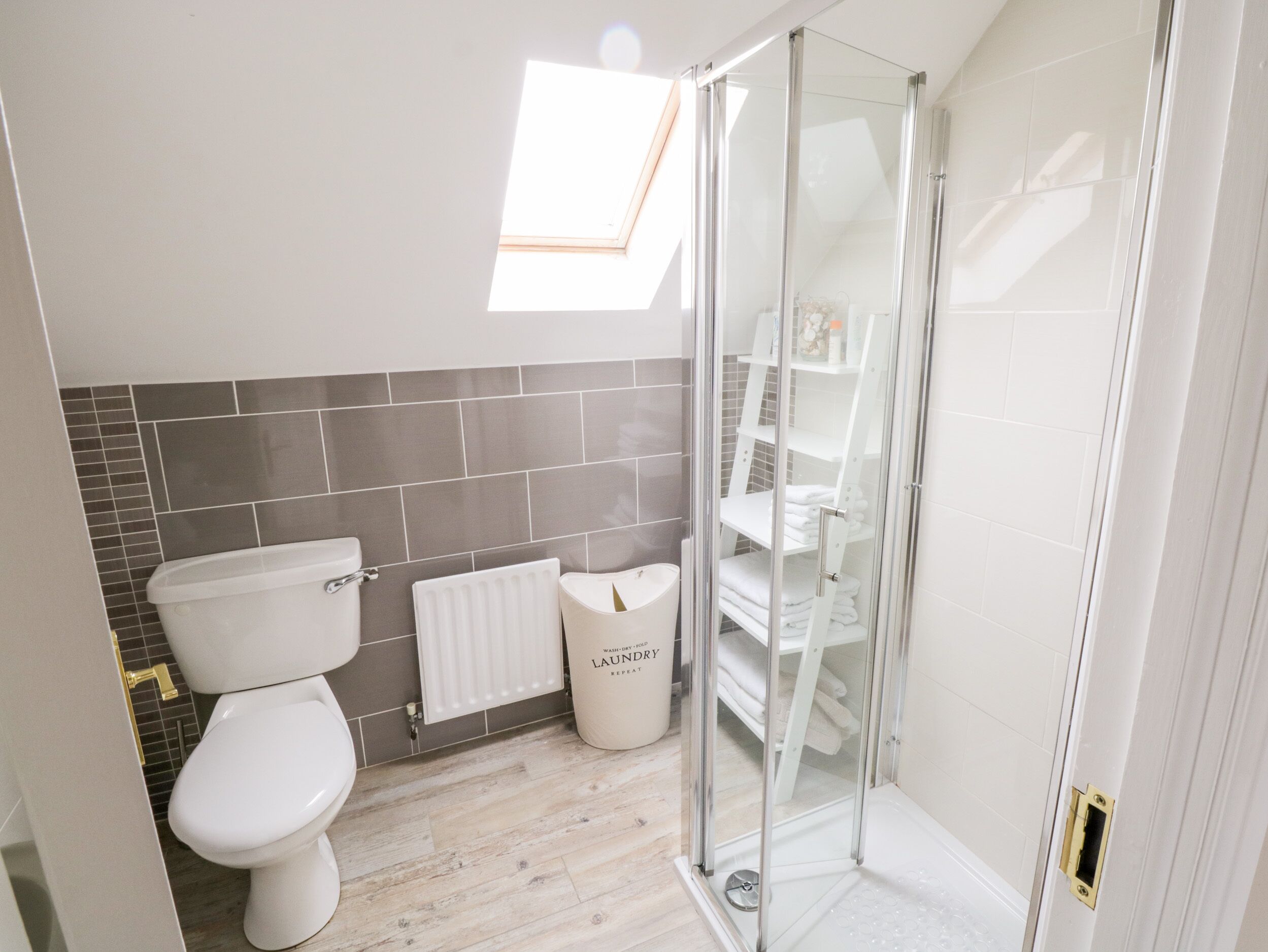 A modern bathroom with a toilet, bidet, and glass shower enclosure.