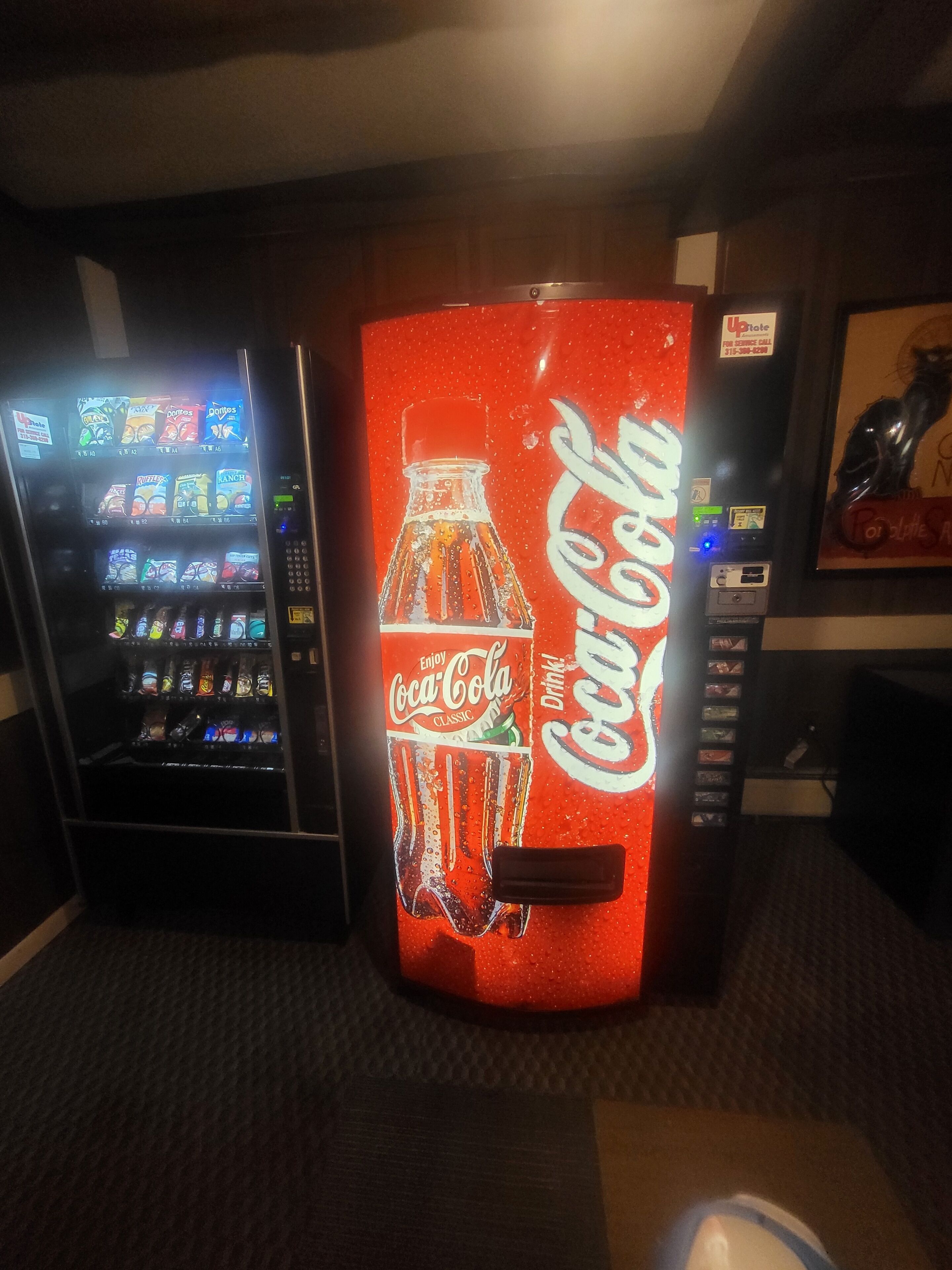 Màquina expenedora amb una beguda Coca-Cola Classic i diverses opcions de menjar.
