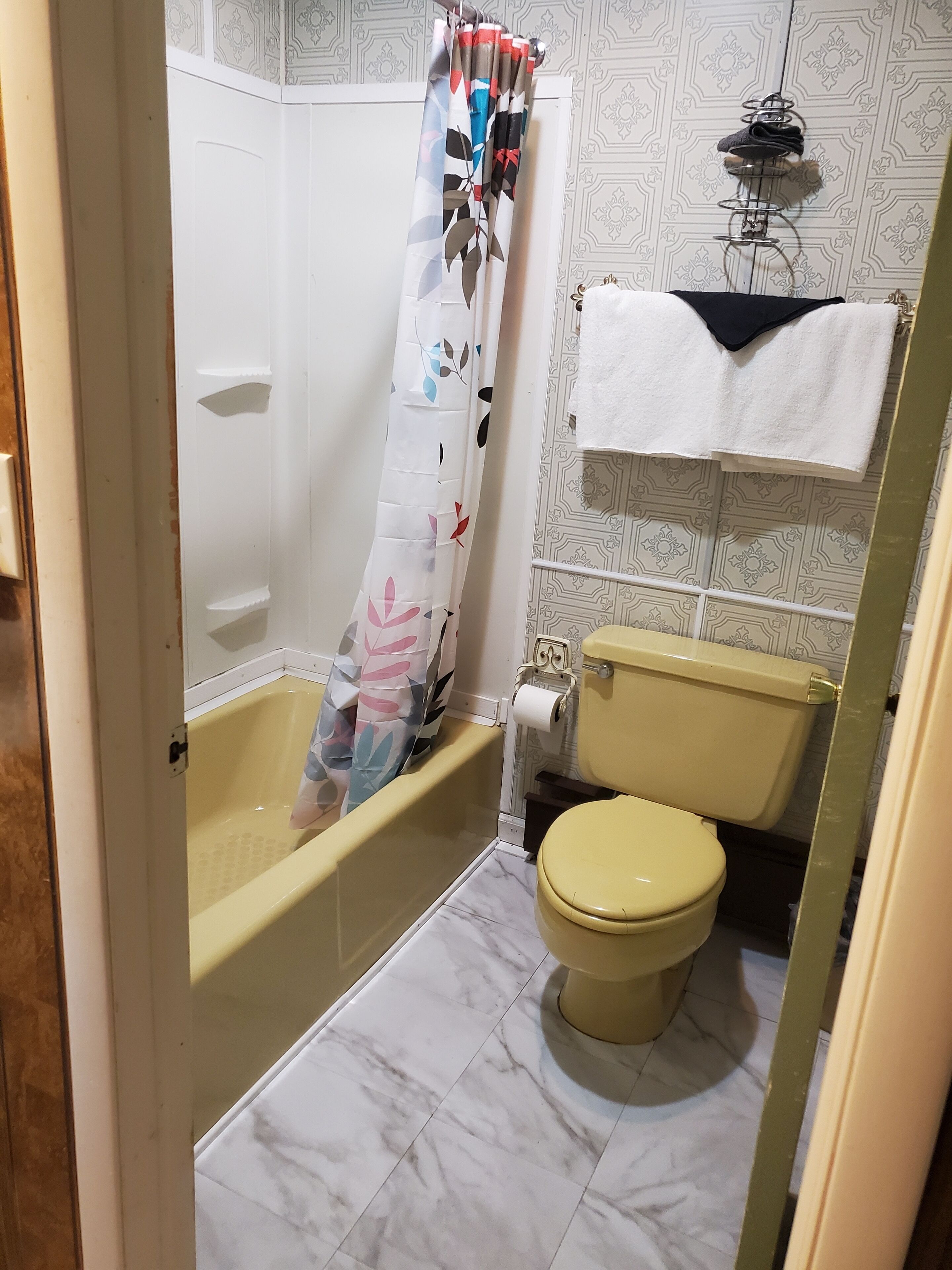 Un baño con bañera, inodoro y cortina de ducha.