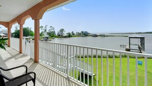 A covered outdoor area with a view of a lake and dock. - Sunset bay view 1 (Pass Christian)