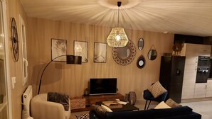 Un soggiorno moderno con un divano, una televisione e decorazioni a parete.