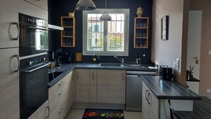Una cucina moderna con elettrodomestici integrati, una finestra vista e mobili in legno.