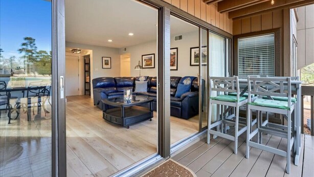 Una sala de estar moderna con un ventanal que da a un patio exterior.