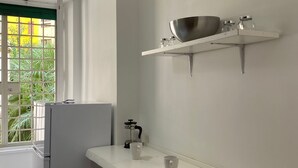 A kitchen with a white countertop, a stainless steel bowl on a hanging shelf, and a coffee maker. - Comfy apartment with 4 double bedrooms, 4 bathrooms and a fully equipped kitchen (Roma)