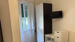 A hotel room with a bed, a desk, a wardrobe, and a television. - Comfy apartment with 4 double bedrooms, 4 bathrooms and a fully equipped kitchen (Roma)