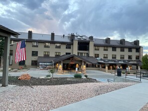 Een meerhoog hotel met een gevel van steen, een overdekte ingang en een Amerikaanse vlag.