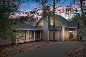 A modern house with a covered porch and a well-lit entrance.