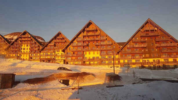 A row of wooden chalet-style buildings with balconies, set in a snowy landscape. - Appart "les luges" 4/6 people valley view large balcony swimming pool  (Besse-et-Saint-Anastaise)