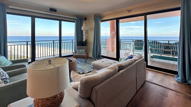Ein geräumiger Balkon mit Meerblick, ausgestattet mit einer Couch, Stühlen und einem Tisch.