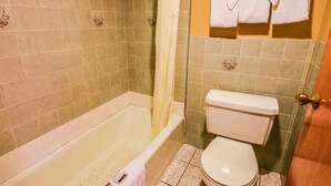 A bathroom with a bathtub, toilet, and a shower curtain. - 1KNS-1 King Non Smoking (Glendale)