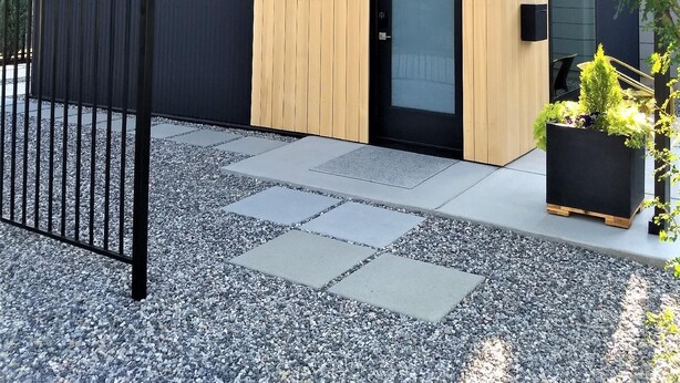 A modern building with a dark facade, a wooden door, and a small window. - Unwind in the sizeable comforts of this small modern space. (Bozeman)