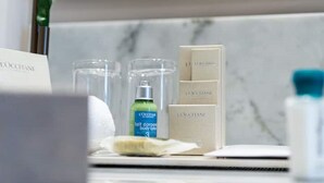 Pesualtaan yläpuolella on L’OCCITANE-vartalovoide ja paperinenäliöpakkaus.