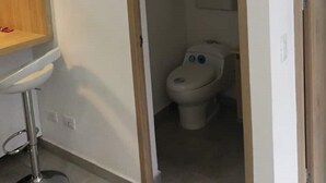 Ein Badezimmer mit Toilette, Waschbecken und Spiegel.
