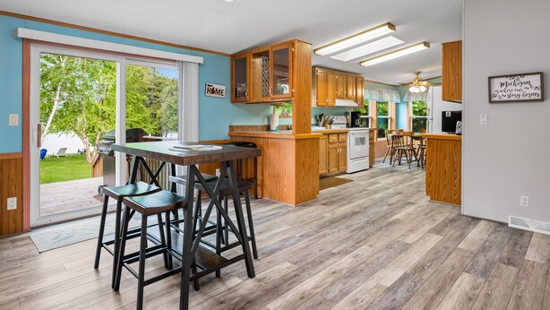 Une cuisine moderne avec des meubles en bois, un îlot central et un coin repas agrémenté de tabourets de bar.