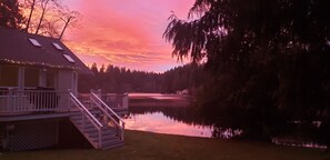 Un chalet au bord du lac, doté d’une terrasse et d’un escalier menant à une zone abritée.