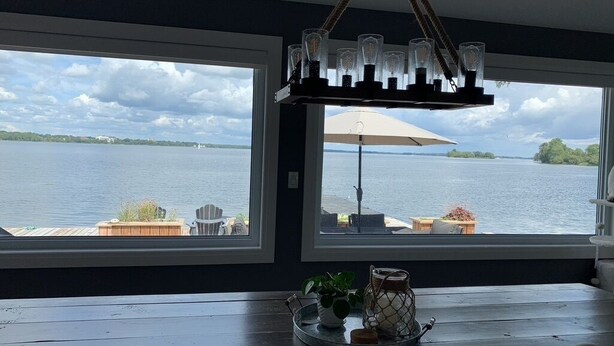 Comedor con vista a un lago, una araña y una mesa con sillas.
