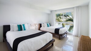 Een hotelkamer met twee bedden, een groot raam met uitzicht op palmbomen en de oceaan, en een helder, schoon interieur.