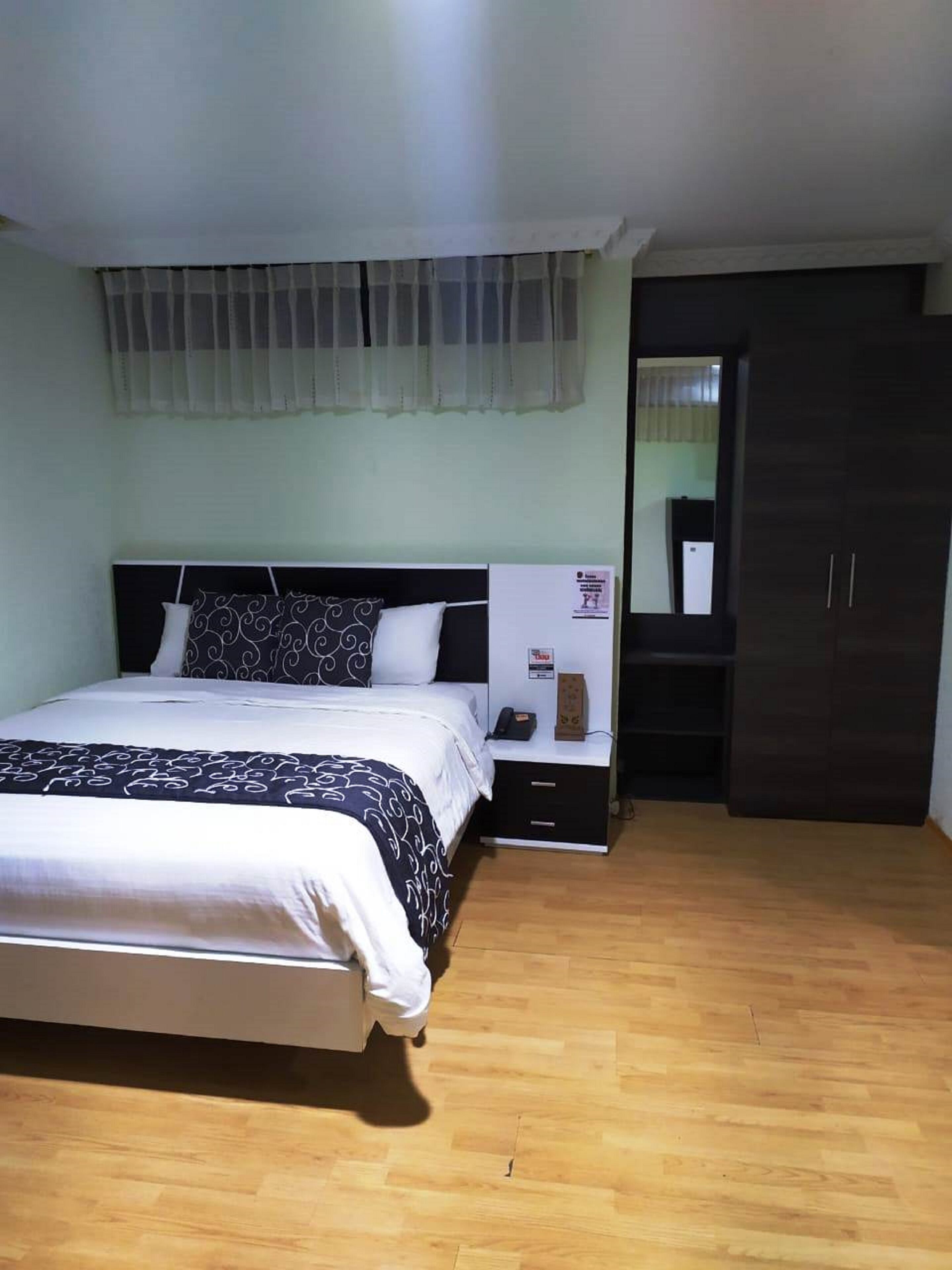 Ein Schlafzimmer mit Bett, Nachttisch und Kleiderschrank.