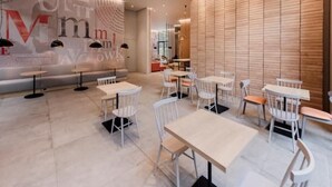 A modern interior with white tables and chairs arranged in a spacious area.
