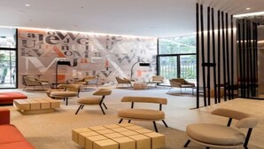 A modern lounge area with multiple seating options, including sofas and chairs, arranged around a central coffee table.