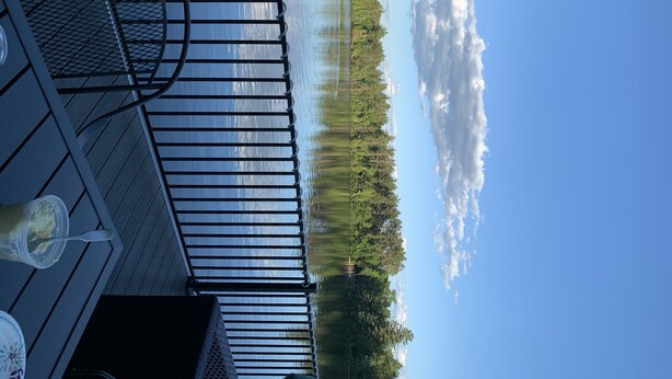 A deck with a view of a lake and forest. - 2 Bedroom Camper with Rooftop Boat House Deck (Gwinn)