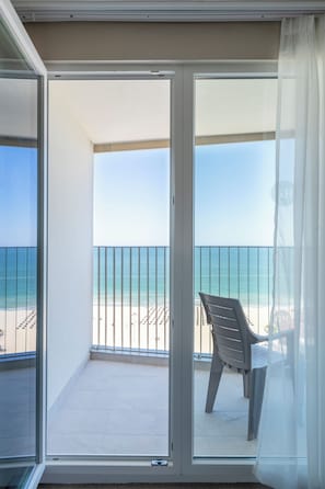 Uma varanda com vista para a praia e o oceano.