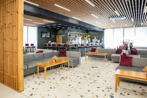 A modern lounge area with a bar, sofas, and a terrazzo floor. - Grand Sunny Beach (Nessebar)