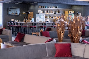 Een bar met zitplaatsen en diverse drankflessen.
